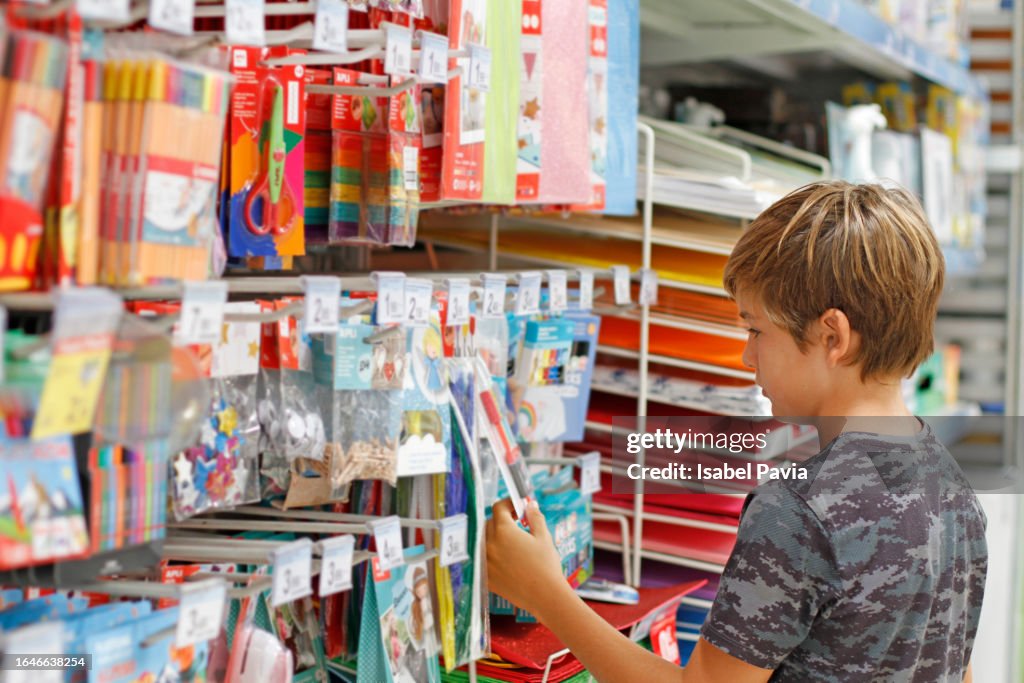Boy looking for arts and crafts equipment at stationery shop