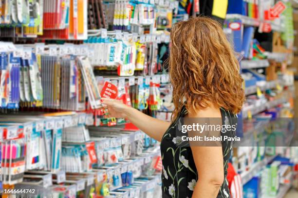 woman shopping for school supplies - utiles escolares fotografías e imágenes de stock