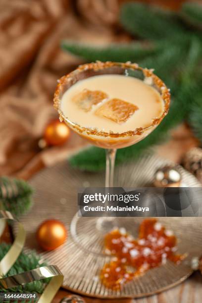 cremiger cocktail martini gesalzenes karamell sahnelikör mit karamellrand und eis für festliche weihnachtsfeier - rustic cocktails stock-fotos und bilder