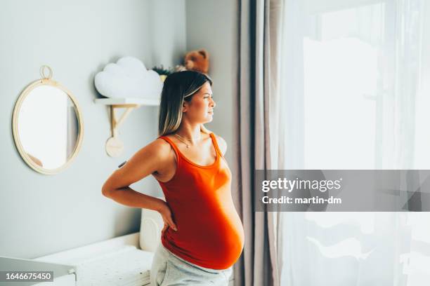 schwangere junge frau mit diabetes zu hause fühlt schmerzen - muskelkontraktion stock-fotos und bilder