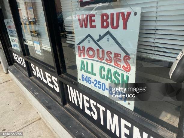 We Buy Houses, All Cash sign in real estate office window, Queens, New York.