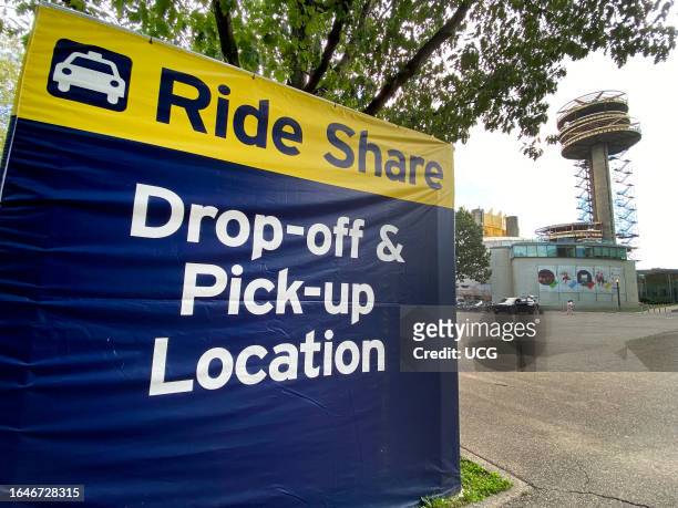 Open, Ride Share pick up and drop off location with NY Pavilion and Queens theater in background, Flushing Meadows Corona Park, Queens, New York.