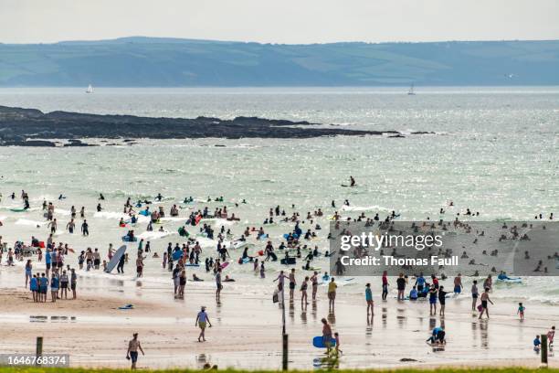 thousands of people in the sea at croyde beach in devon - croyde beach stock pictures, royalty-free photos & images
