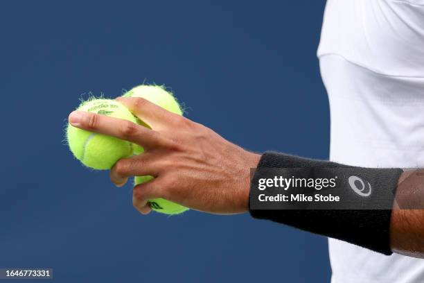 Arthur Fils of France holds three tennis balls on serve against Tallon Griekspoor of Netherlands during their Men's Singles First Round match on Day...