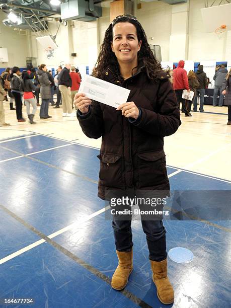 Carol Perez, an occupational therapist and Long Beach resident, holds a $1,000 debit card she received from Cantor Fitzgerald LP's Hurricane Sandy...