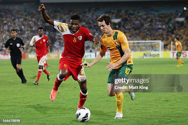 Robbie Kruse of the Socceroos is challenged by Ali Nahar of Oman during the FIFA 2014 World Cup Qualifier match between the Australian Socceroos and...