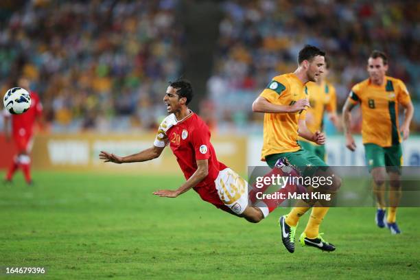 Amad Al Hosni of Oman is brought down after a challenge from Robbie Cornthwaite of the Socceroos during the FIFA 2014 World Cup Qualifier match...