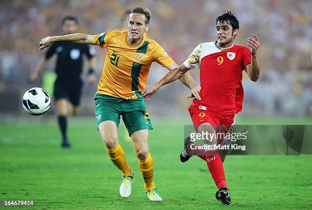 Michael Thwaite of the Socceroos challenges Abdulaziz Al-Miqbali of Oman during the FIFA 2014 World Cup Qualifier match between the Australian...