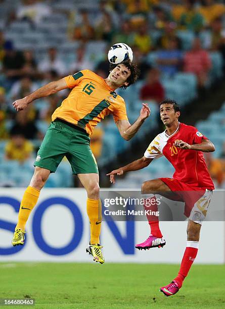 Mile Jedinak of the Socceroos heads the ball in front of Amad Al Hosni of Oman during the FIFA 2014 World Cup Qualifier match between the Australian...