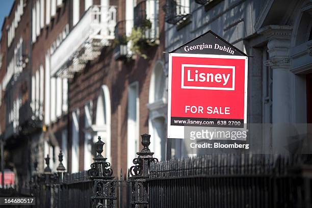 An estate agent's 'For Sale' board sits outside a Georgian house on Merrion Square in Dublin, Ireland, on Saturday, March 16, 2013. Ireland’s renewed...