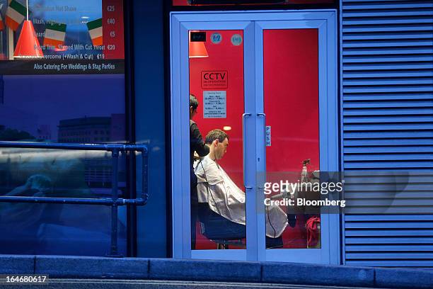 Man sits for a haircut inside a barber shop in the docklands area of Dublin, Ireland, on Thursday, March 14, 2013. Ireland’s renewed competiveness...