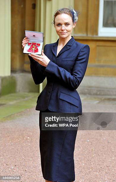Fashion designer Stella McCartney holds her Officer of the British Empire award after the Investiture Ceremon at Buckingham Palace on March 26, 2013...