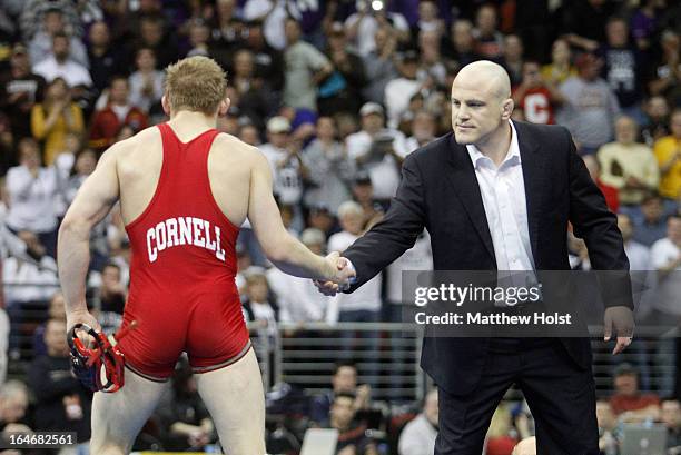 Head coach Cael Sanderson of the Penn State Nittany Lions shakes hands with Kyle Dake of the Cornell Big Red after he defeated David Taylor of the...