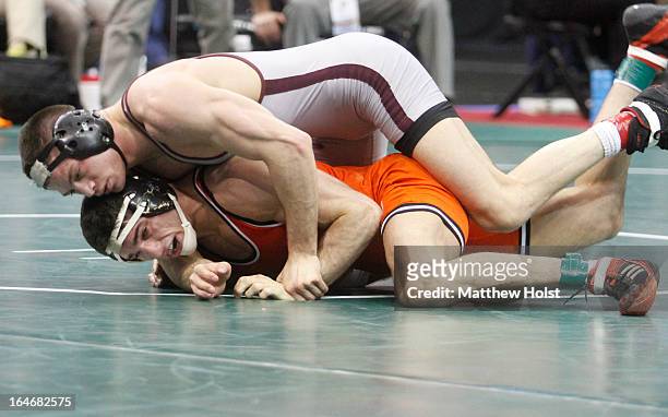 Tyler Caldwell of the Oklahoma State Cowboys wrestles Peter Yates of the Virginia Tech Hokies in their 165-pound 3rd-place match at the 2013 NCAA...