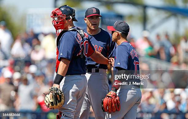 Pitcher Alfredo Aceves of the Boston Red Sox is restrained by catcher Ryan Lavarnway during a Grapefruit League Spring Training Game against the...