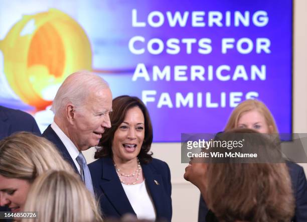 President Joe Biden and Vice President Kamala Harris greet audience members during an event promoting lower healthcare costs in the East Room of the...