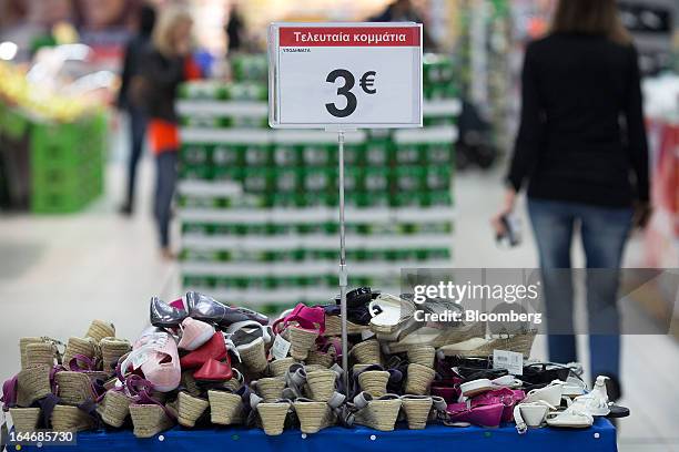 Women's footwear sits on display beneath a three euro sign inside a Carrefour SA supermarket at the Mall of Cyprus in Nicosia, Cyprus, on Tuesday,...