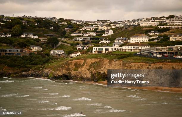 General view as a surfer rides a wave at Mawgan Porth Beach on August 29, 2023 in Mawgan Porth, United Kingdom.