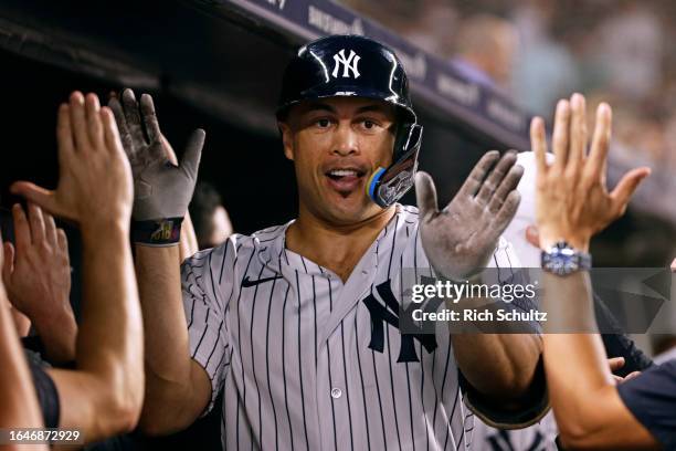 Giancarlo Stanton of the New York Yankees is congratulated by teammates after he hit a two-run home run against the Detroit Tigers during the sixth...