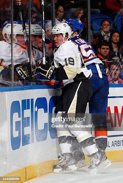 Beau Bennett of the Pittsburgh Penguins and Joe Finley of the New York Islanders hit the boards in an NHL hockey game at Nassau Veterans Memorial...