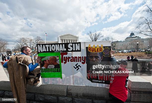 Same-sex marriage opponent Alan Hoyle of the Wake Up Call Ministry and a follower hold a sign across from the US Supreme Court in Washington on March...