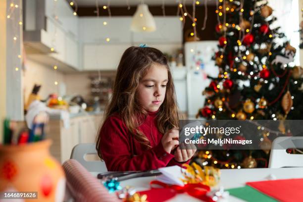 creative child playing with items and making christmas cards and ornaments at home - trabalho manual imagens e fotografias de stock
