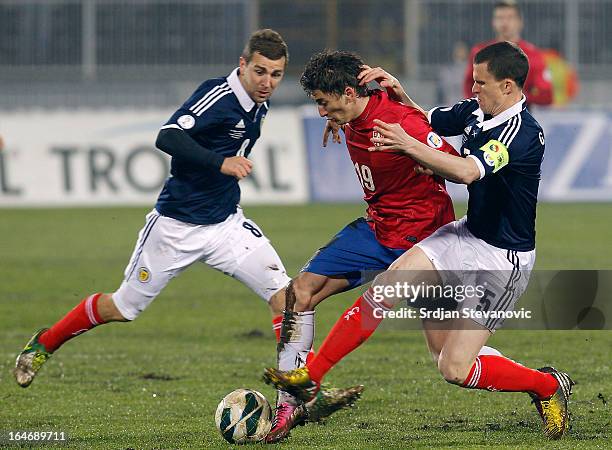 Filip Djuricic of Serbia is challenged by Gary Caldwell and James McArthur of Scotland during the FIFA 2014 World Cup Qualifier match between Serbia...
