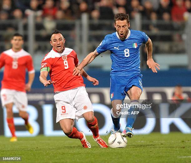 Italy's Claudio Marchisio vies with Malta's captain, Michael Mifsud during the FIFA 2014 World Cup qualifying football match Malta vs.Italy at the...