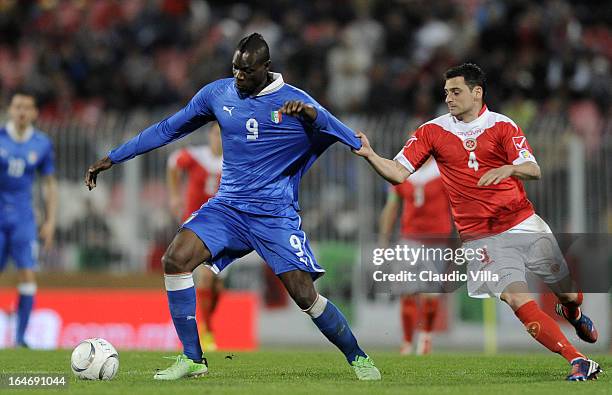 Mario Balotelli of Italy#9 and Gareth Sciberras of Malta compete for the ball during the FIFA 2014 World Cup qualifier match between Malta and Italy...