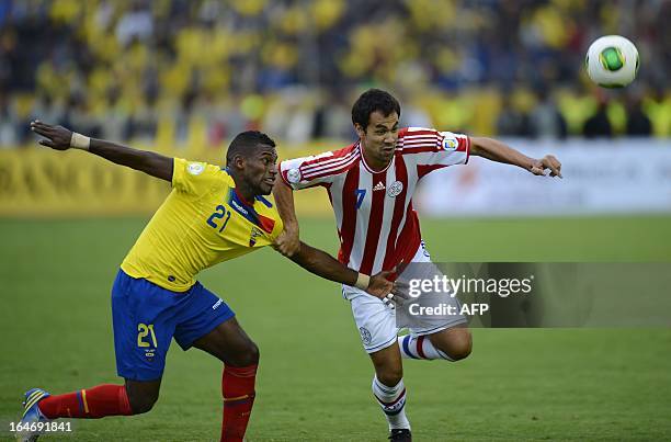 Paraguayan forward Oscar Cardozo and Ecuador's defender Gabriel Achillier struggle for the ball during their FIFA World Cup Brazil 2014 South...