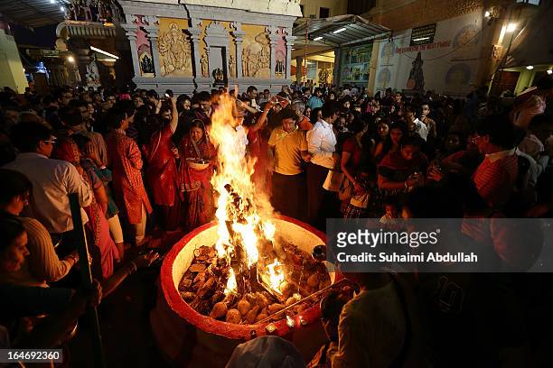 People gather around the bornfire to offer prayers as they celebrate Holika Dahan on March 26, 2013 in Singapore. Holika Dahan, or burning of demon...