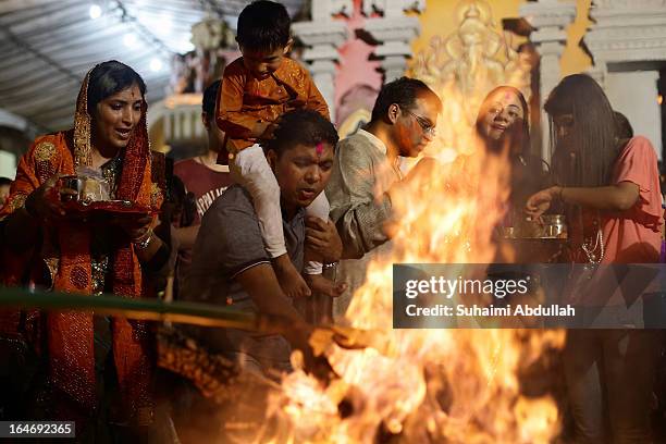 People gather around the bornfire to offer prayers as they celebrate Holika Dahan on March 26, 2013 in Singapore. Holika Dahan, or burning of demon...