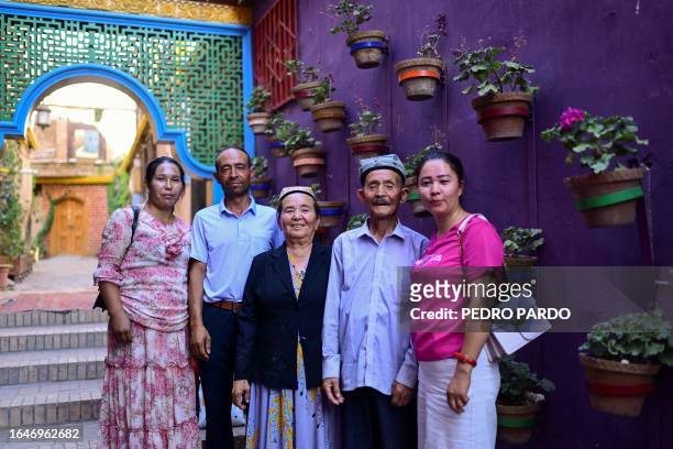 This photo taken on July 13, 2023 shows a Uyghur family posing for a picture in the Old Kashgar tourist area in China's northwestern Xinjiang region....