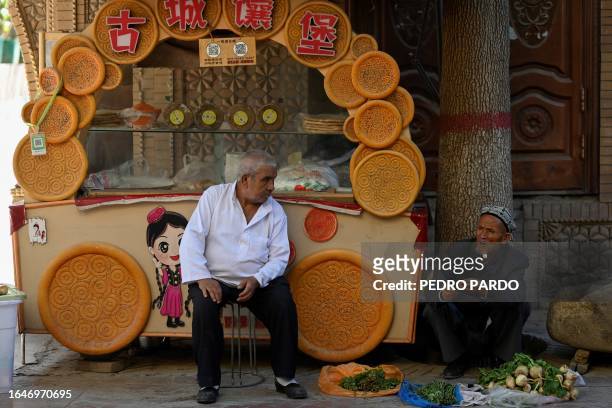 This photo taken on July 13, 2023 shows Uyghur men selling their products at the Old Kashgar tourist area in China's northwestern Xinjiang region....