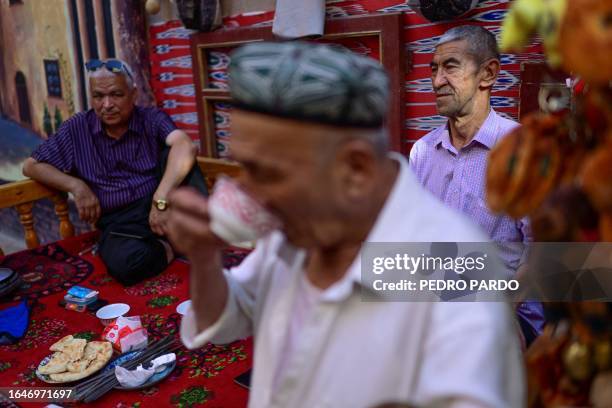 This photo taken on July 13, 2023 shows local men drinking tea in the Old Kashgar tourist area in China's northwestern Xinjiang region. Chinese...