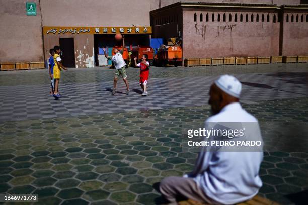 This photo taken on July 13, 2023 shows local children playing with a ball in the Old Kashgar tourist area in China's northwestern Xinjiang region....