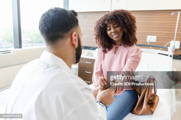 unrecognizable er doctor gently touches woman's injured wrist and arm - wrist stock pictures, royalty-free photos & images