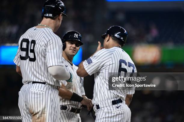 New York Yankees center fielder Jasson Dominguez is greeted by New York Yankees right fielder Aaron Judge and New York Yankees third base coach Luis...