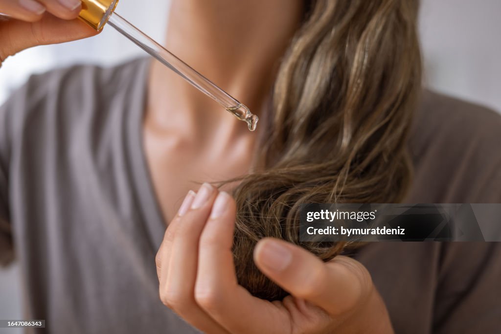 Applying natural organic essential oil on hair