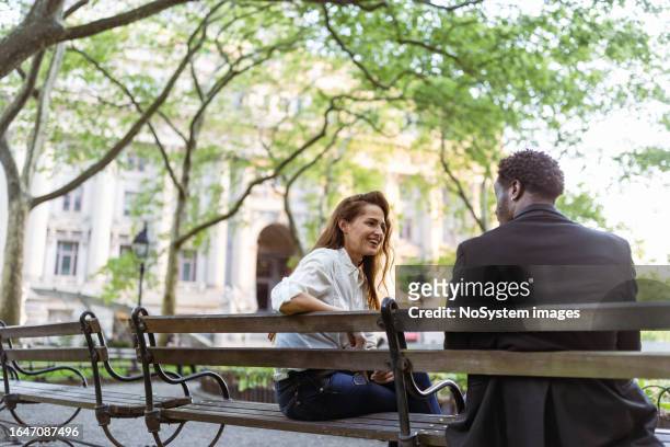 business people chatting in a wall street park - businesswoman nyc stockfoto's en -beelden