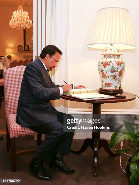 Sultan of Brunei Darussalam, His Majesty Hassanal Bolkiah signs a book recognising his visit before an official dinner at Premier House on March 27,...
