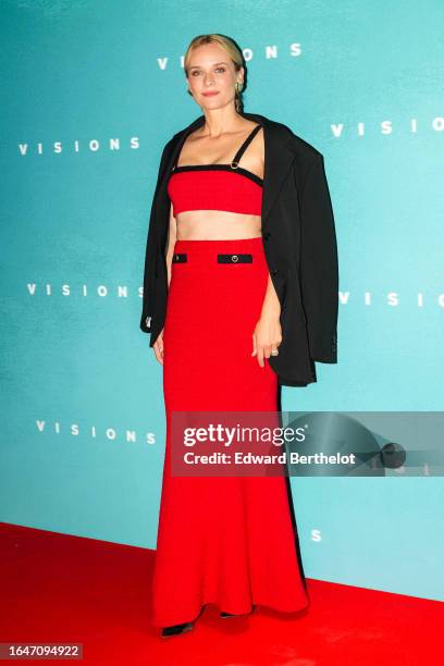 Diane Kruger wears golden earrings, a black oversize blazer jacket, a red and black tweed checkered cropped top, a gathered long matching maxi skirt,...