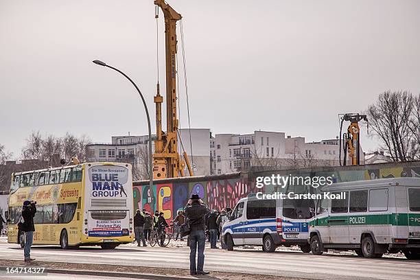 Sightseeing bus passes by a section of the Berlin Wall which has been removed to make way for a luxury apartments development on March 27, 2013 in...