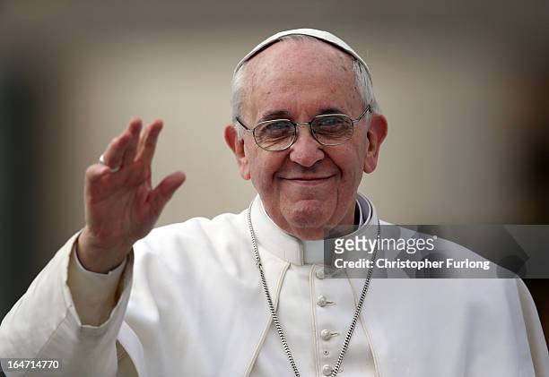 Pope Francis waves to the crowd as he drives around St Peter's Square ahead of his first weekly general audience as pope on March 27, 2013 in Vatican...