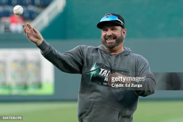 Country artist Garth Brooks throws out the first pitch prior to a game between the Pittsburgh Pirates and Kansas City Royals at Kauffman Stadium on...