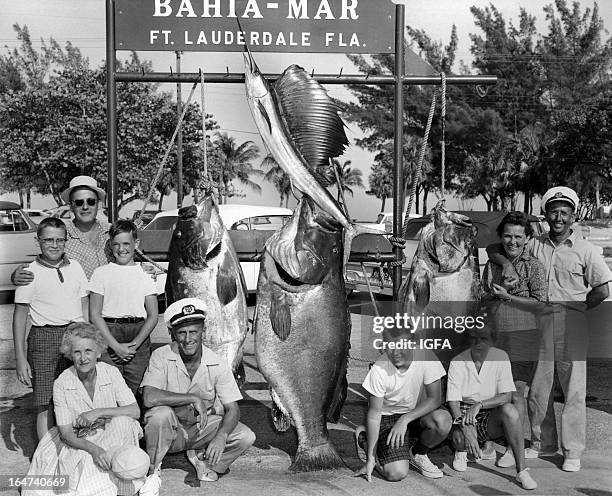 Carol Chance poses at Bahia Mar dock with a group of anglers, three large goliath groupers and one sailfish caught in the waters near Fort...