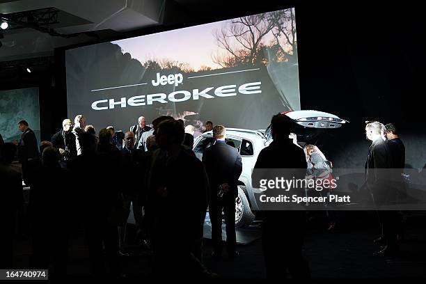 People look at the new version of the Jeep Cherokee, the fourth since 1974, is displayed at the 2013 New York International Auto Show on March 27,...
