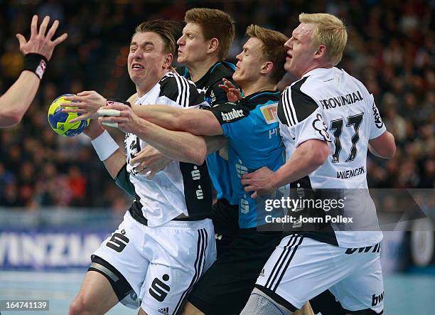 Filip Jicha of Kiel is challenged by Toon Leenders and Niclas Pieczkowski of Essen during the DKB Handball Bundesliga match between THW Kiel and...