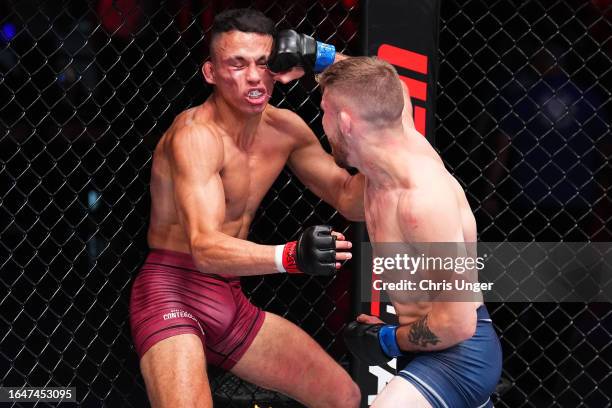 Mateo Vogel of Canada punches Timothy Cuamba in their featherweight fight during Dana White's Contender Series season seven, week four at UFC APEX on...