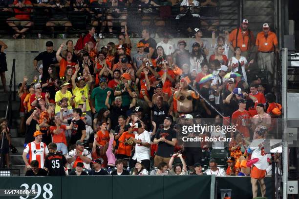 Fans are sprayed with water in the outfield after the Baltimore Orioles scored in the seventh inning against the Chicago White Sox at Oriole Park at...